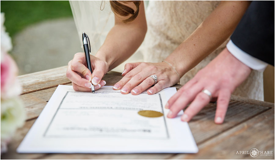 Signing marriage license on a picnic table at Chatfield Botanic Gardens in Colorado