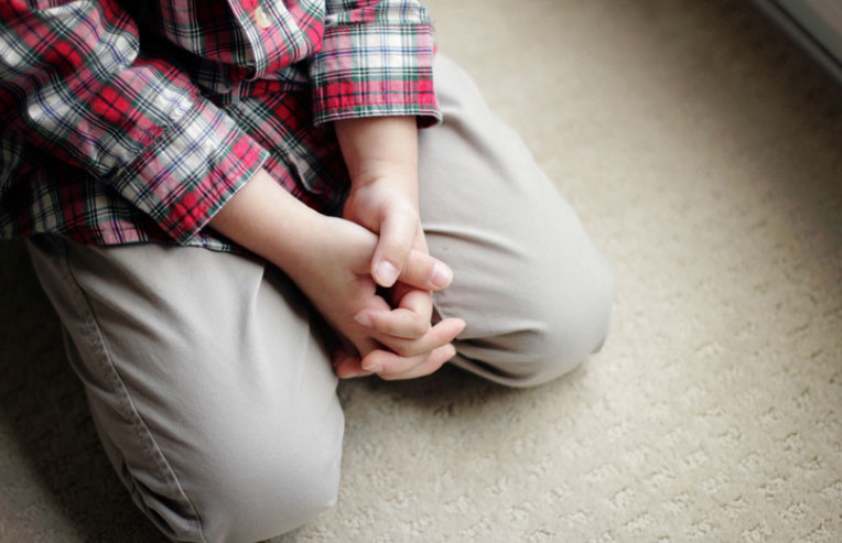 boy kneeling and praying