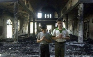 crianças egípcias oram nas ruínas das instalações de uma igreja incendiada 